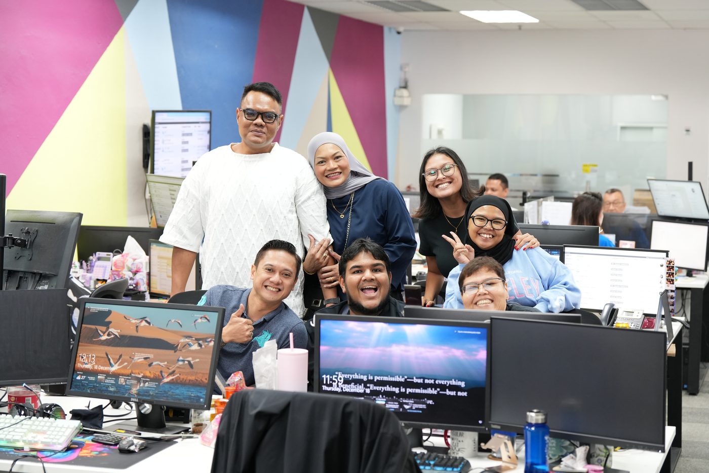 Connect Centre team members giving thumbs up together at the office